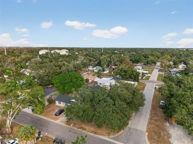 an aerial view of residential houses with outdoor space and trees