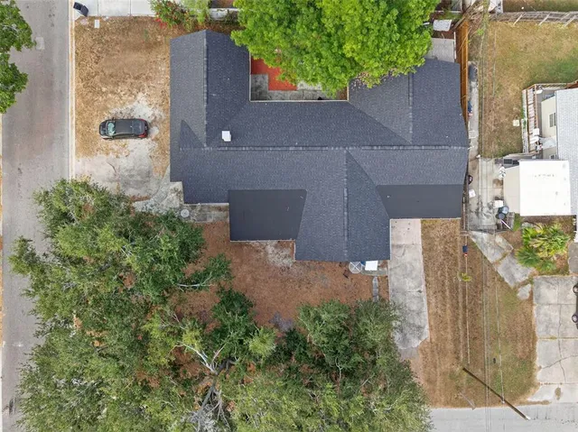 an aerial view of a house with a yard and large tree