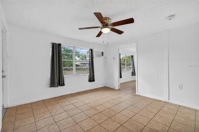 an empty room with windows and fan