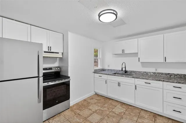 a kitchen with granite countertop cabinets and steel stainless steel appliances