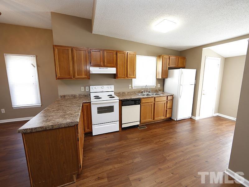919 Dale Street Durham, NC 27701 - Photo 2 of 16 a kitchen with stainless steel appliances granite countertop white cabinets a sink a stove a refrigerator and island with wooden floor