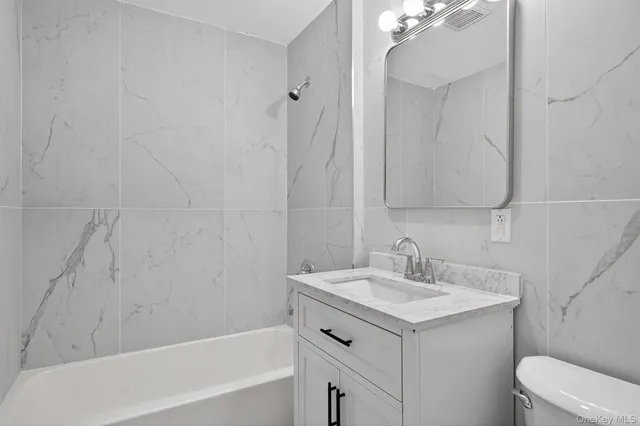 a bathroom with a sink toilet vanity and tub