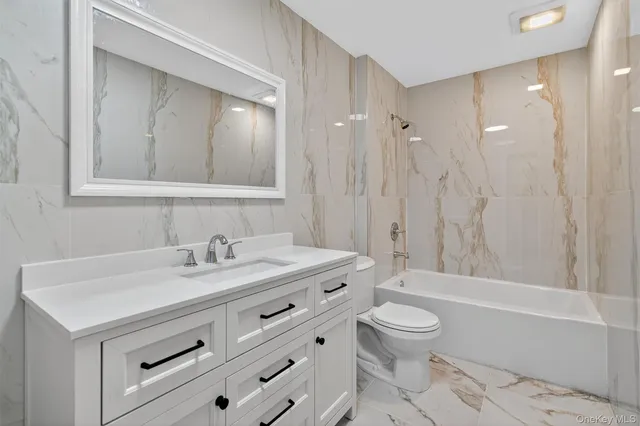 a bathroom with a sink a toilet and a large mirror