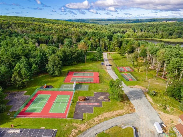 a view of a tennis court with a couch and wooden floor
