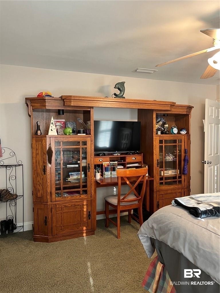 16311 Old Brady Road Bay Minette, AL 36507 - Photo 28 of 38 Carpeted room featuring a built-in wood media console with integrated desk space, display cabinetry, and storage