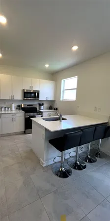 a kitchen with a sink refrigerator and cabinets