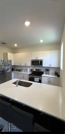 a kitchen with stainless steel appliances a sink a stove top oven a counter space and cabinets