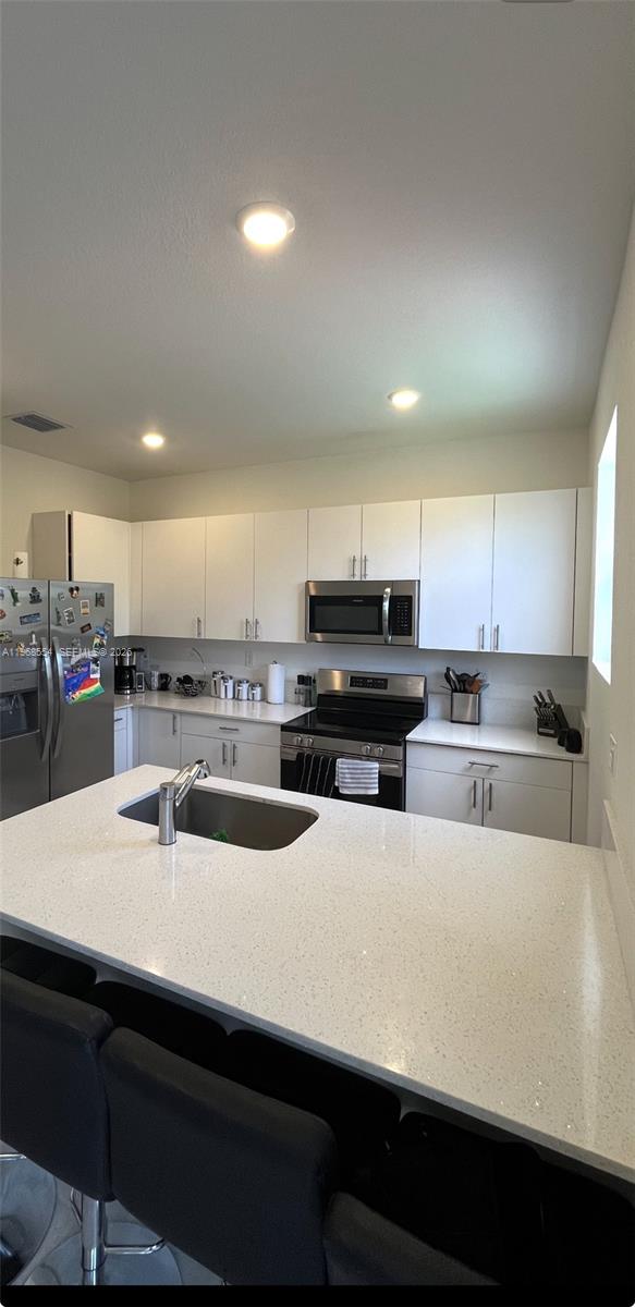 17982 Southwest 359th Street Homestead, FL 33034 - Photo 10 of 17 a kitchen with stainless steel appliances a sink a stove top oven a counter space and cabinets