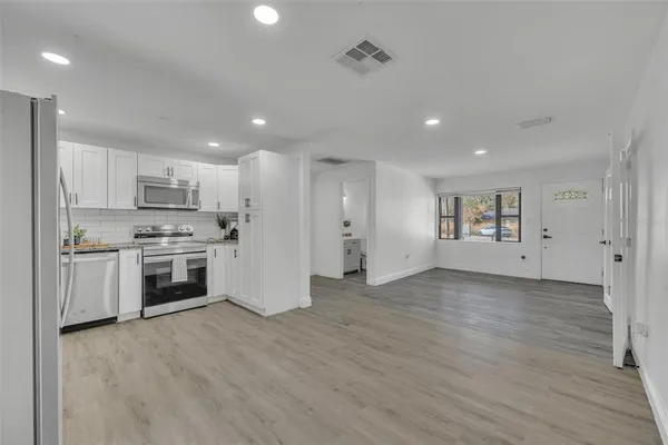 a view of a kitchen with a sink stove and cabinets