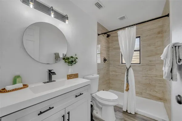 a bathroom with a sink a toilet and a mirror