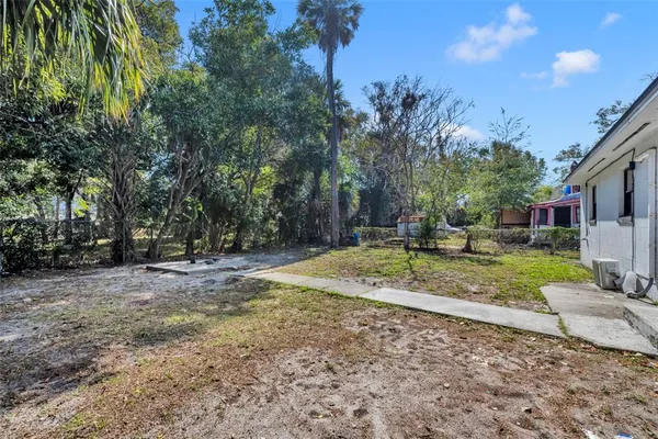 a backyard of a house with barbeque oven table and chairs