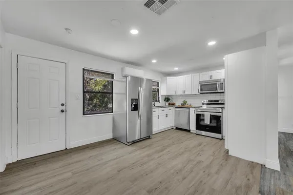 a kitchen with white cabinets and white appliances