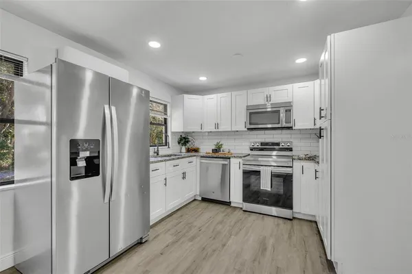 a kitchen with stainless steel appliances a refrigerator sink and microwave