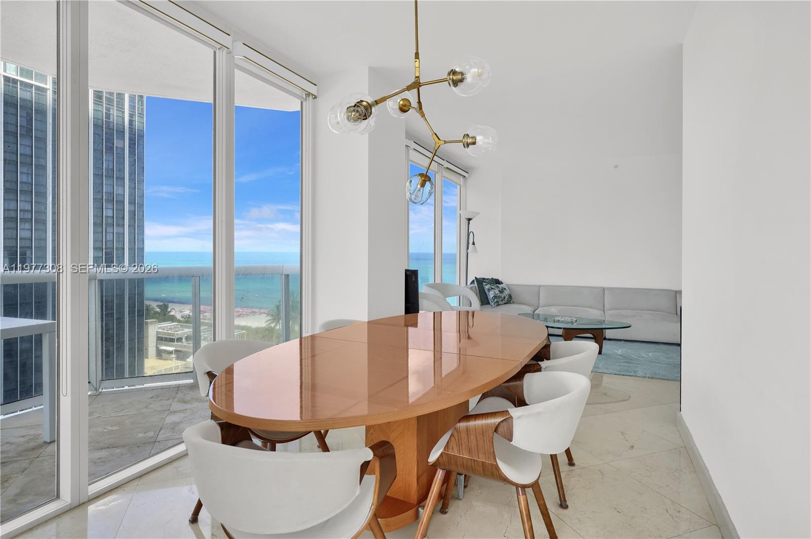 4779 Collins Avenue, Unit 1007 Miami Beach, FL 33140 - Photo 19 of 56 a dining room with furniture and a floor to ceiling window