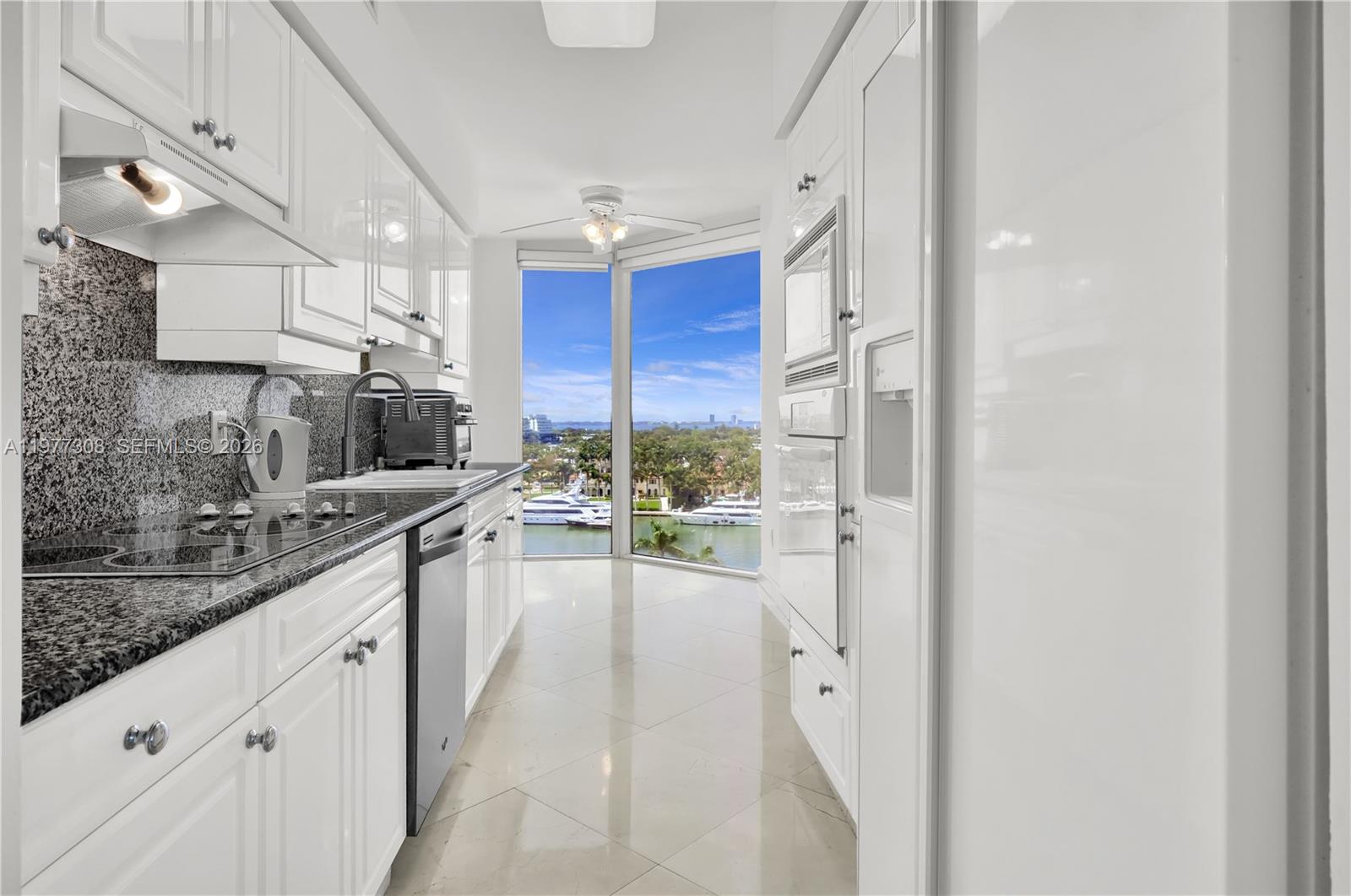 4779 Collins Avenue, Unit 1007 Miami Beach, FL 33140 - Photo 20 of 56 a large white kitchen with a large window