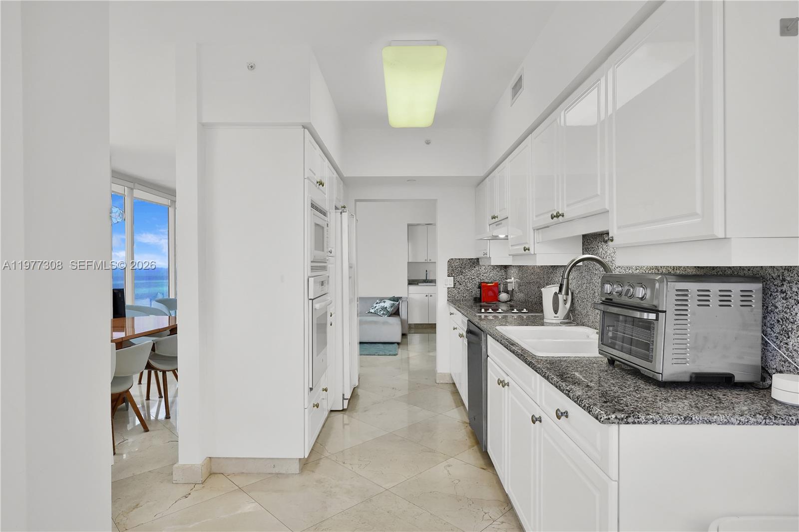 4779 Collins Avenue, Unit 1007 Miami Beach, FL 33140 - Photo 22 of 56 a kitchen that has a lot of cabinets in it