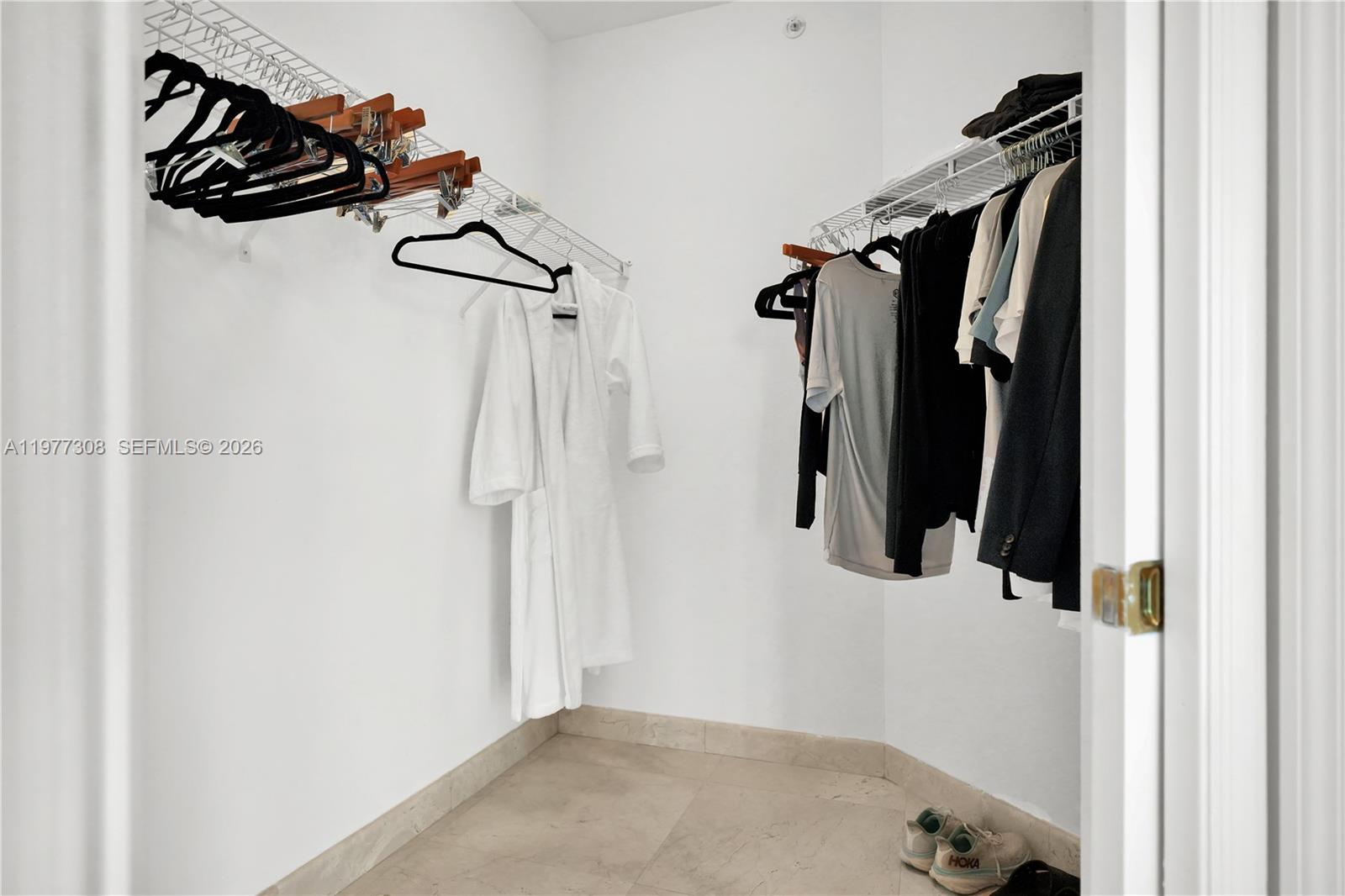 4779 Collins Avenue, Unit 1007 Miami Beach, FL 33140 - Photo 27 of 56 a view of walk in closet with clothes and shoes