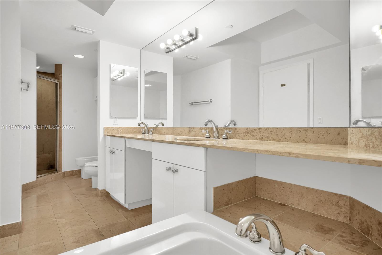 4779 Collins Avenue, Unit 1007 Miami Beach, FL 33140 - Photo 29 of 56 a en suite bathroom with a sink and a mirror