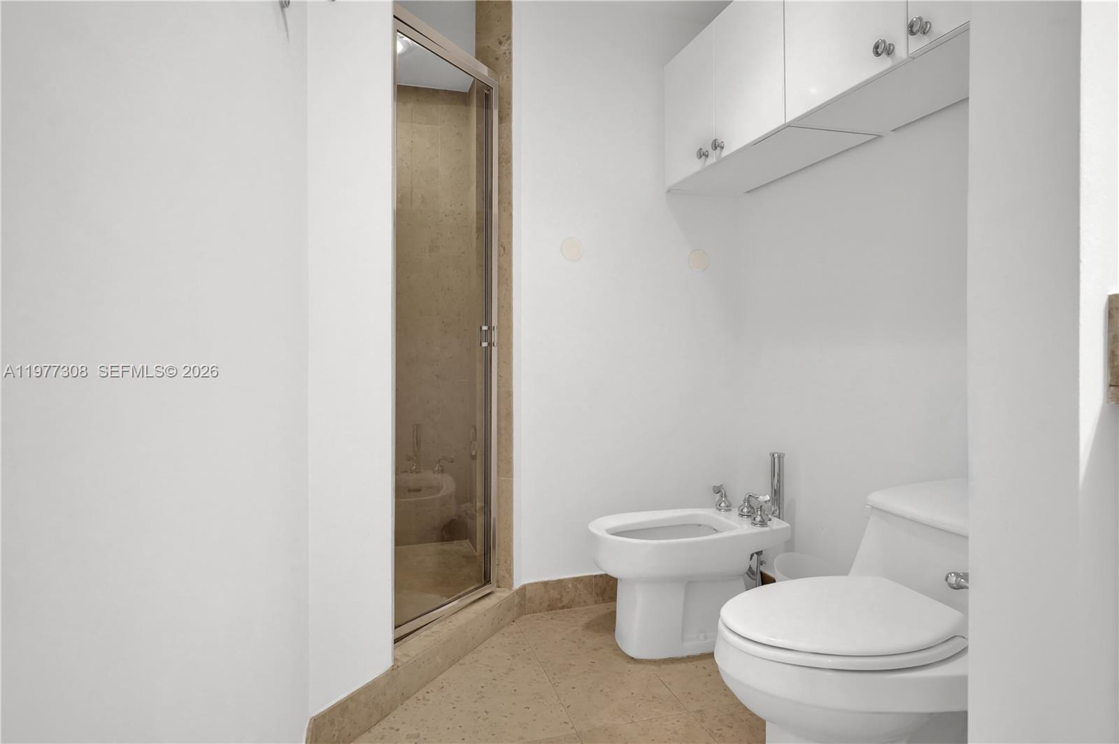 4779 Collins Avenue, Unit 1007 Miami Beach, FL 33140 - Photo 30 of 56 a white toilet sitting next to a bathroom sink