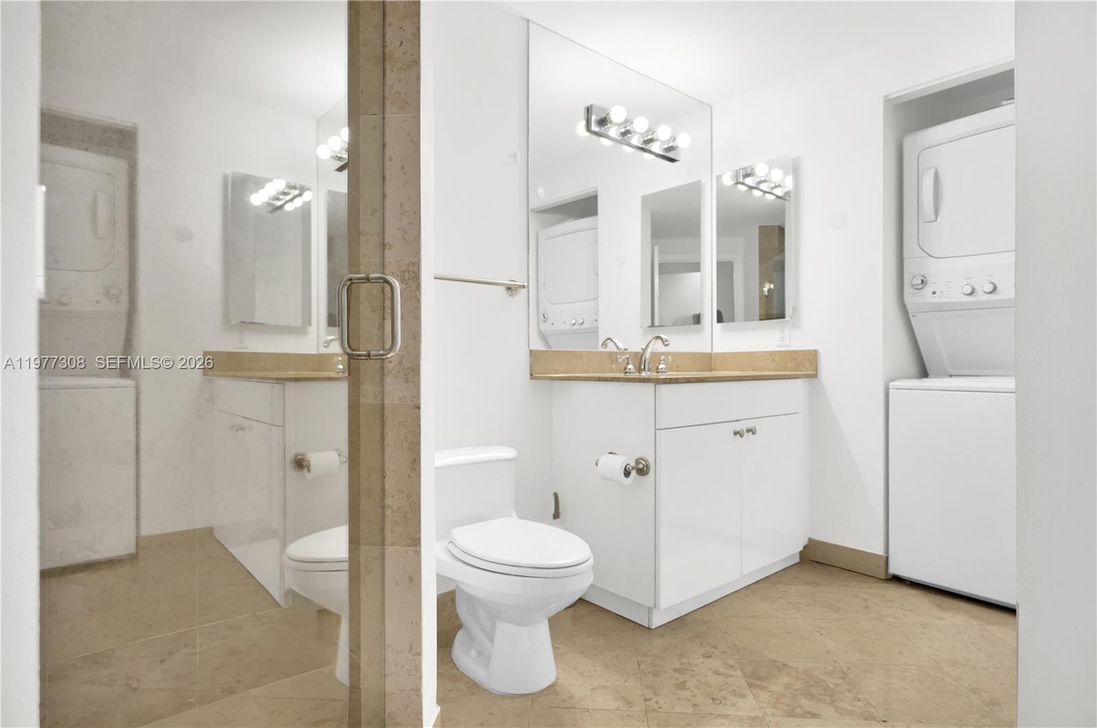 4779 Collins Avenue, Unit 1007 Miami Beach, FL 33140 - Photo 33 of 56 a spacious bathroom with a toilet a sink and a mirror