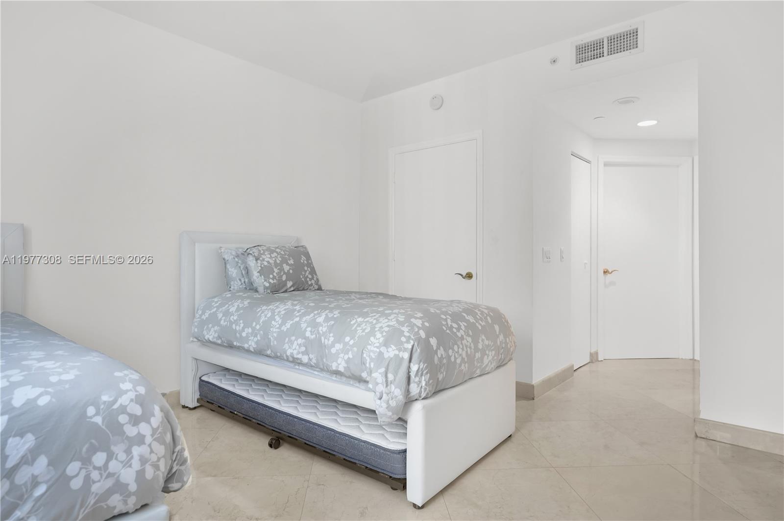 4779 Collins Avenue, Unit 1007 Miami Beach, FL 33140 - Photo 37 of 56 a spacious bedroom with a bed and a table