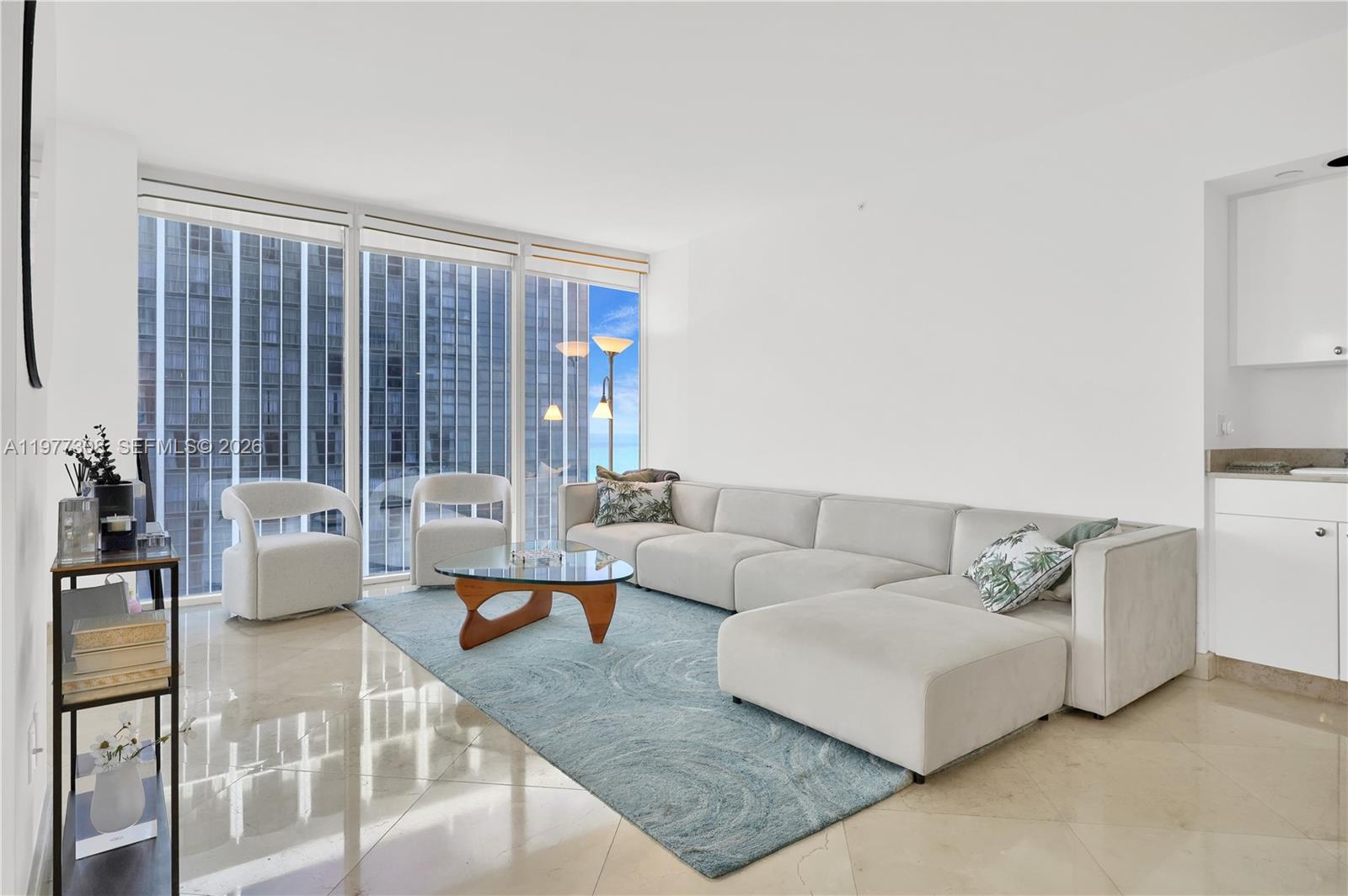 4779 Collins Avenue, Unit 1007 Miami Beach, FL 33140 - Photo 5 of 56 a living room with furniture and large windows