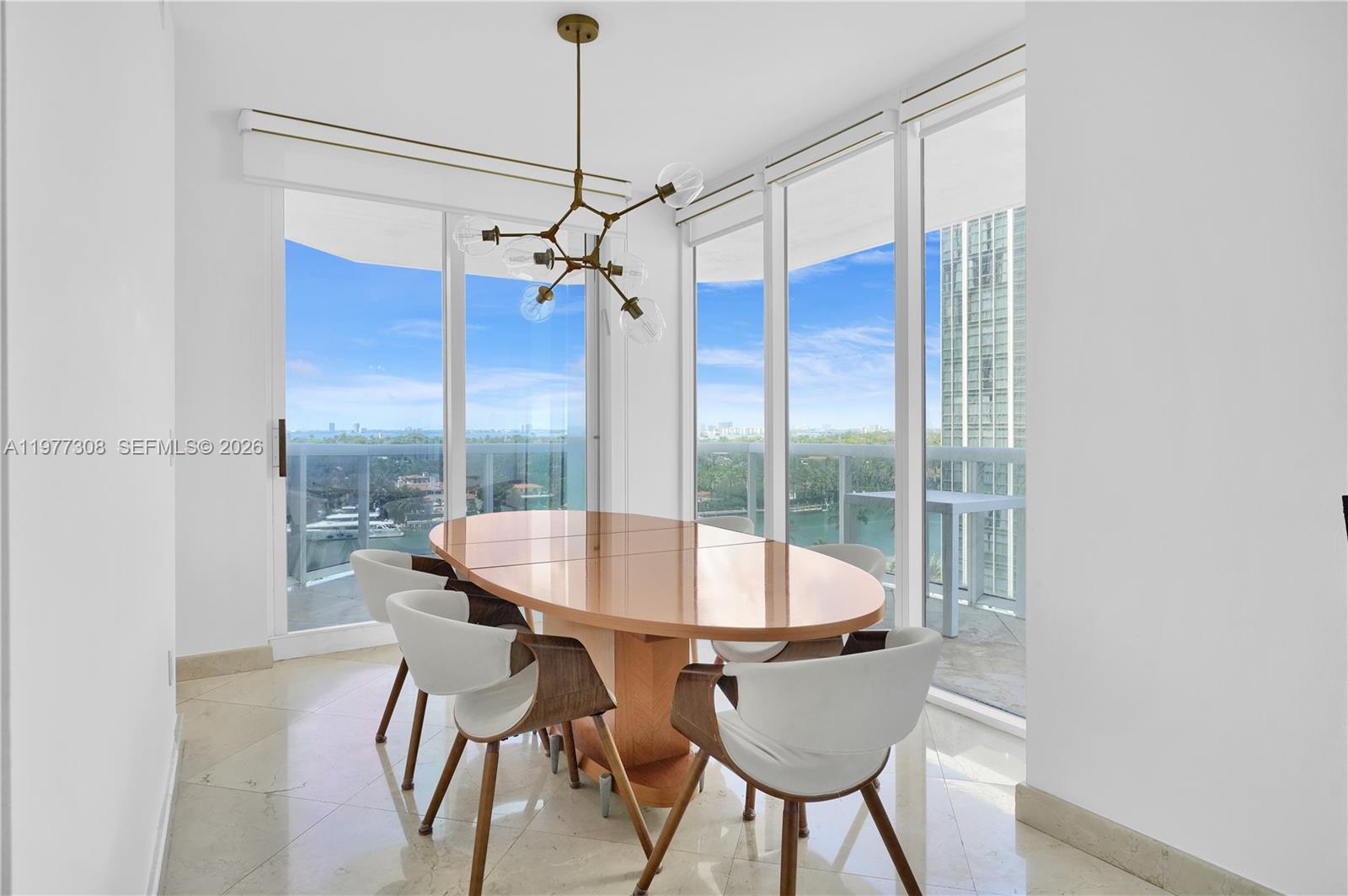 4779 Collins Avenue, Unit 1007 Miami Beach, FL 33140 - Photo 8 of 56 a view of a dining room with furniture wooden floor and chandelier
