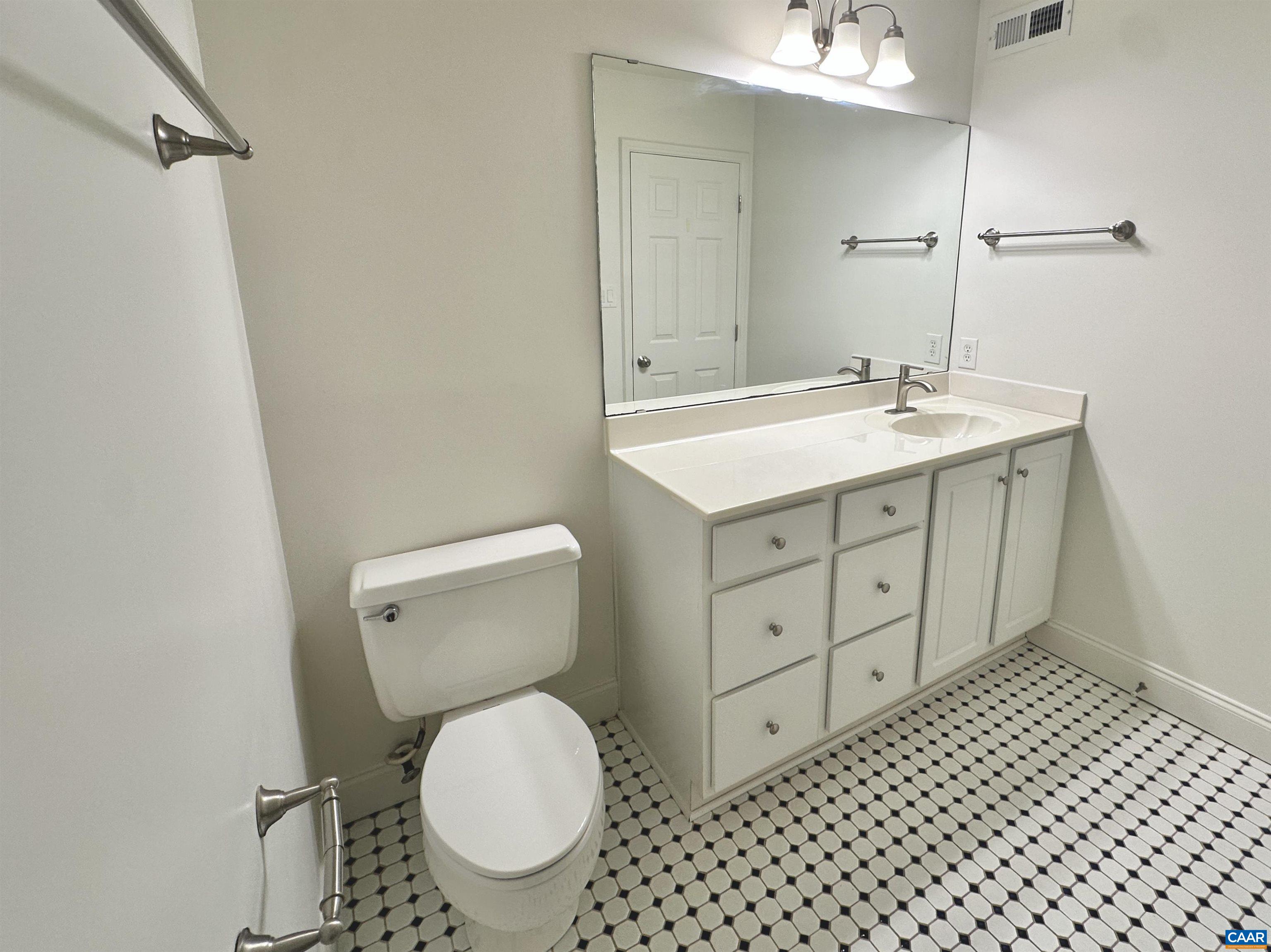 104 Turtle Creek Road, Unit 9 Charlottesville, VA 22901 - Photo 13 of 23 a bathroom with a granite countertop toilet sink and mirror