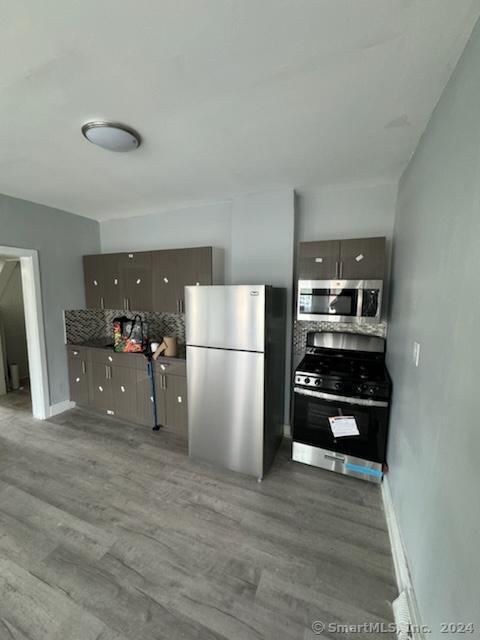 a kitchen with stainless steel appliances a refrigerator a stove a microwave and a refrigerator
