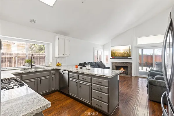 a kitchen with a stove sink and a granite counter top