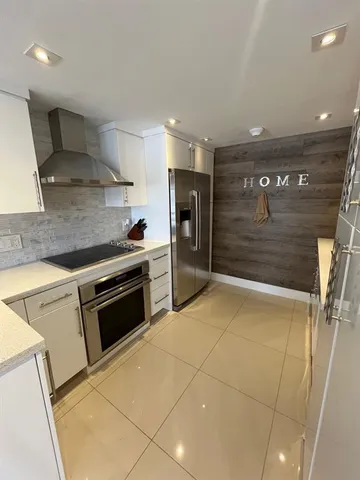 a kitchen with stainless steel appliances granite countertop a stove a sink and a refrigerator