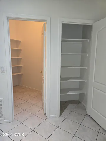 a view of walk in closet with empty racks