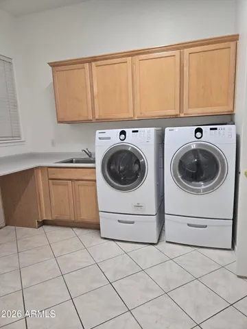 a utility room with sink dryer and washer