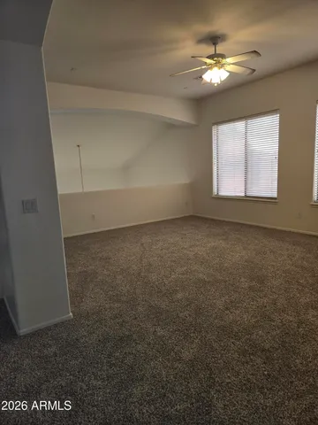 en empty room with windows and ceiling fan