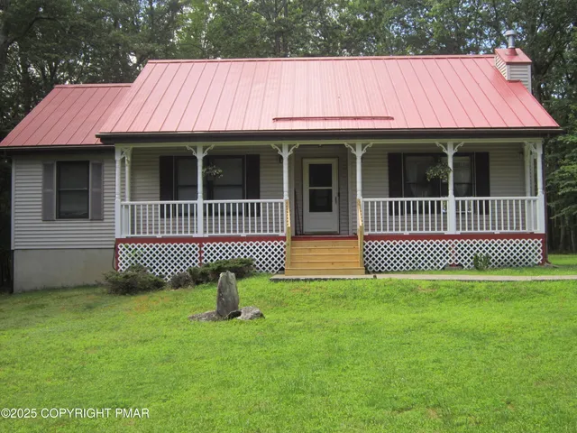 a view of a house with a deck and a yard