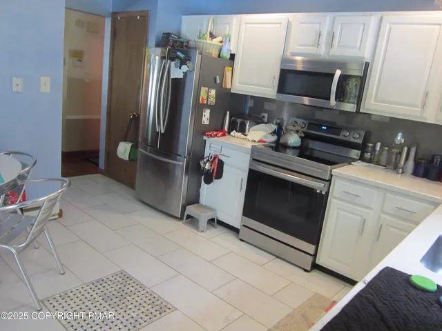 a kitchen with stainless steel appliances a stove a microwave and a refrigerator