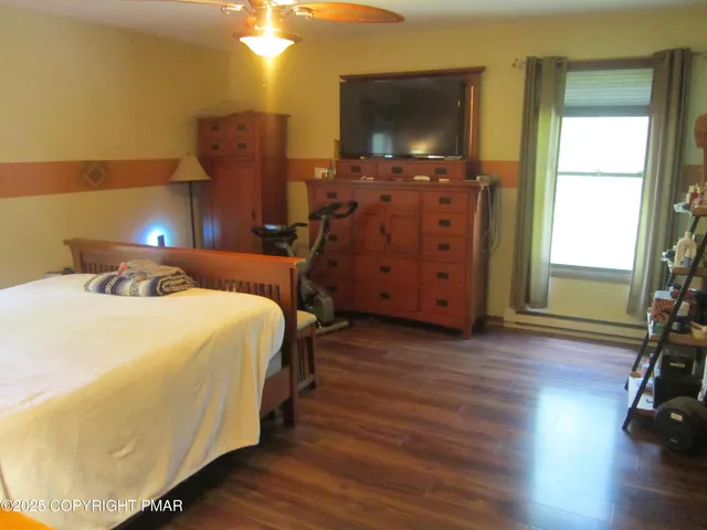 a bedroom with a bed and a flat tv screen on dresser