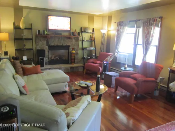a living room with furniture fireplace and a large window