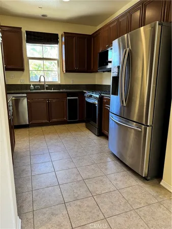 a kitchen with granite countertop a refrigerator and a sink