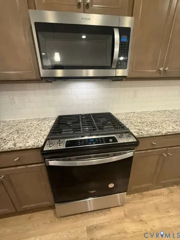 a stove top oven sitting inside of a kitchen