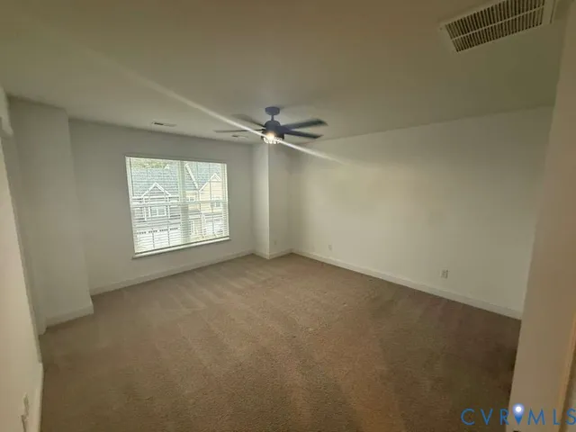 an empty room with windows and fan