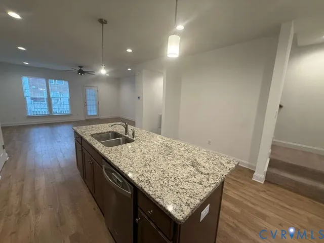 a kitchen with a sink stove and wooden floor