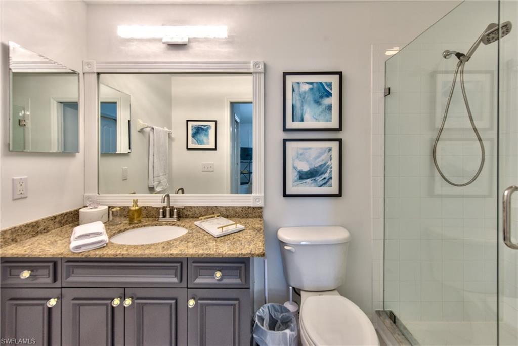 21340 Lancaster Run, Unit 1327 Estero, FL 33928 - Photo 13 of 27 a bathroom with a granite countertop toilet a sink and a mirror