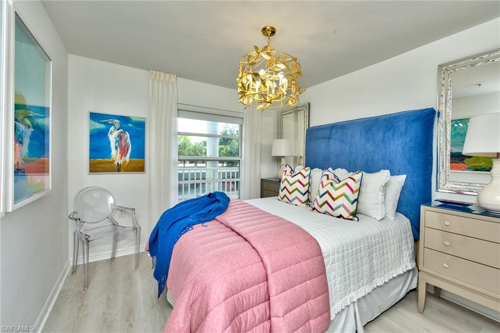 21340 Lancaster Run, Unit 1327 Estero, FL 33928 - Photo 14 of 27 a bedroom with a bed and a chandelier