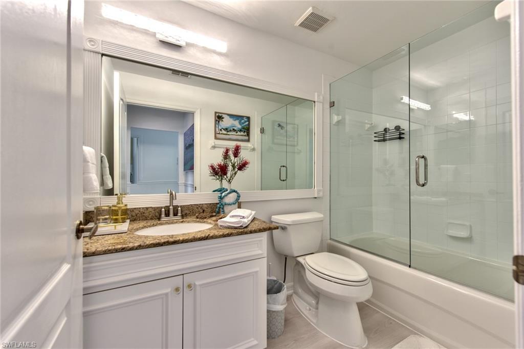 21340 Lancaster Run, Unit 1327 Estero, FL 33928 - Photo 15 of 27 a bathroom with a granite countertop toilet a sink a mirror a shower a vanity and window
