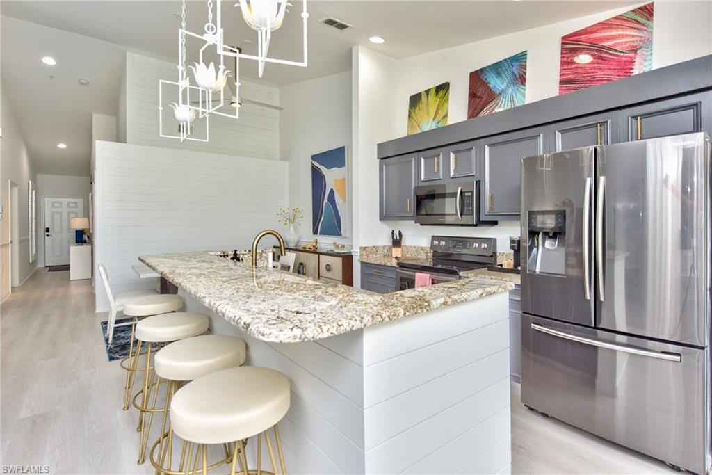 21340 Lancaster Run, Unit 1327 Estero, FL 33928 - Photo 8 of 27 a kitchen with stainless steel appliances granite countertop a sink refrigerator and cabinets