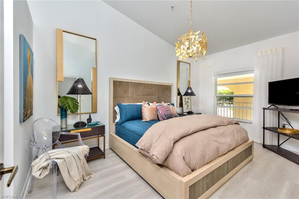 21340 Lancaster Run, Unit 1327 Estero, FL 33928 - Photo 10 of 27 a bedroom with bed a couch and a chandelier