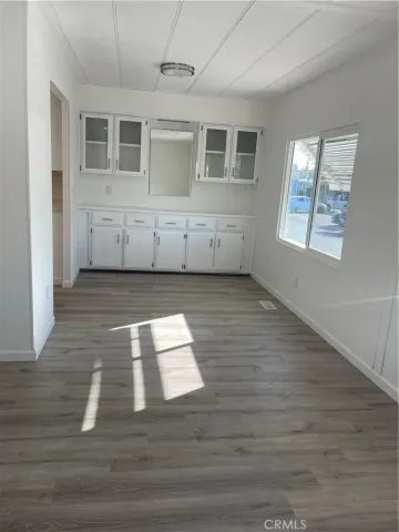 a view of an empty room with wooden floor and windows