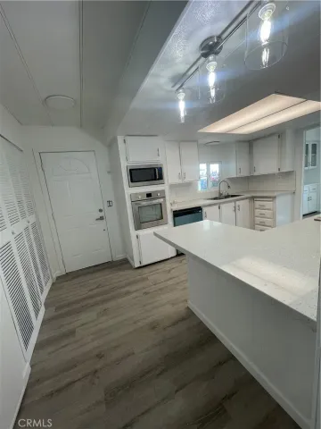 a large kitchen with cabinets and wooden floor