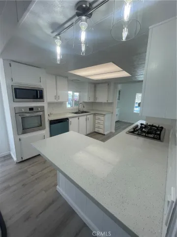 a kitchen with stainless steel appliances a sink dishwasher stove and refrigerator